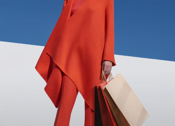 Woman dressed in red carrying shopping bags