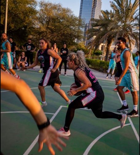 Group Of Young People Playing Basketball Outdoors